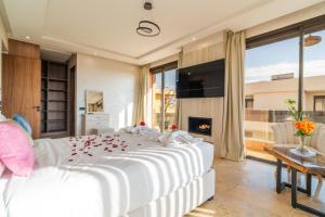 ein Schlafzimmer mit einem großen weißen Bett mit Rosen darauf in der Unterkunft Luxury Villa Hammam Piscine chauffeé sans Vis Avis in El Harkat + 86 Fotos