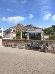 منتجع أحجار لبيوت العطلات في الطائف: مبنى على جدار حجري مع جبل في الخلفية