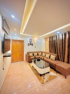 a living room with a couch and a coffee table at Mini cinema 1 bed Apartment Al Qamar Heights in Murree +12 photos
