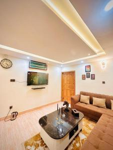 a living room with a couch and a table at Mini cinema 1 bed Apartment Al Qamar Heights in Murree