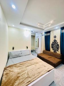 a bedroom with two beds and blue curtains at Mini cinema 1 bed Apartment Al Qamar Heights in Murree