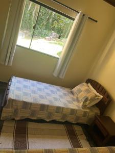 Ένα ή περισσότερα κρεβάτια σε δωμάτιο στο Sítio com água mineral, rio e cachoeira