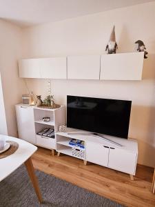 a living room with a white entertainment center with a flat screen tv at Ferienwohnung Harzgefühl in Elbingerode