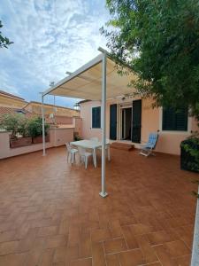 een terras met een tafel en stoelen onder een luifel bij Villa Maria in La Maddalena