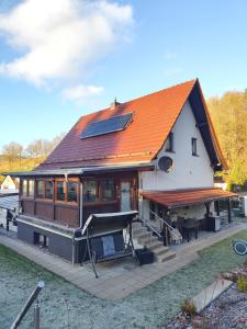 una grande casa con un tetto arancione con un tavolo da biliardo di Ferienwohnung Bamberger mit Wintergarten a Smalcalda