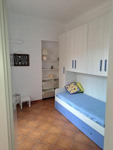 een kleine kamer met een bed en witte kasten bij Villa Maria in La Maddalena