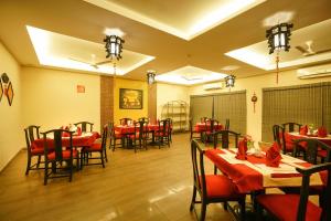 Un comedor con mesas y sillas rojas. en Super Townhouse Mookkannoor Tourist Home, en Kochi
