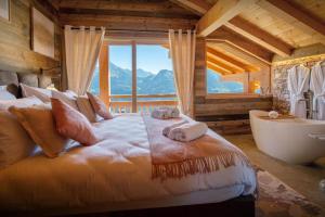 Chalet Serbijanka Alpine Retreat with Hammam Sauna and Jacuzzi for 14 Gueststs في مانيجود: غرفة نوم بسرير كبير مع حوض ونافذة