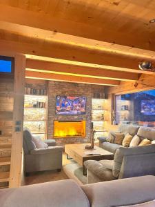 Chalet Serbijanka Alpine Retreat with Hammam Sauna and Jacuzzi for 14 Gueststs في مانيجود: غرفة معيشة مع كنب ومدفأة