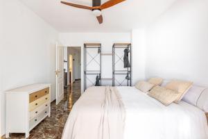 una camera con letto bianco e ventilatore a soffitto di Miramar a Castell de Ferro