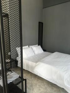a bedroom with a bed with white sheets at Letsios Steel2 in Kalabaka +2 photos