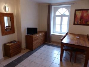 a room with a desk and a television and a window at B&B Domaine de La Corbe in Bournezeau