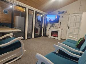 a waiting room with chairs and a tv and a fireplace at Casuta Din Poveste Gold Craiova in Craiova