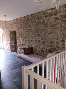 ein Schlafzimmer mit einem Bett an einer Backsteinwand in der Unterkunft La métairie de Laura in Gesvres