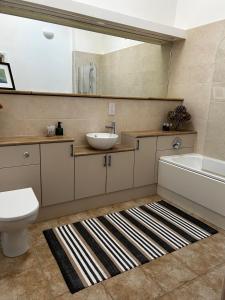 a bathroom with a sink and a toilet and a mirror at The Stable at Woodhouse Farm in Montacute +49 photos