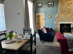 a living room with a table and a fireplace at The Stable at Woodhouse Farm in Montacute
