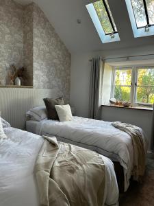two beds in a bedroom with a skylight at The Stable at Woodhouse Farm in Montacute