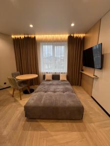 a bedroom with a bed and a tv and a table at Апартаменти Перемоги 1 in Mukacheve