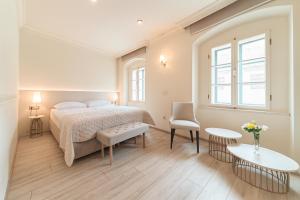 een slaapkamer met een bed, een tafel en een stoel bij Vogel Rooms Tvrđa Osijek in Osijek +13 foto's