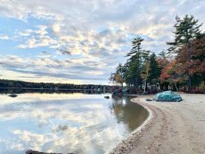 un corpo di acqua con alberi e nuvole nel cielo di Suissevale Lake Retreat - Hot Tub, Beach and Games ad Abbeyville