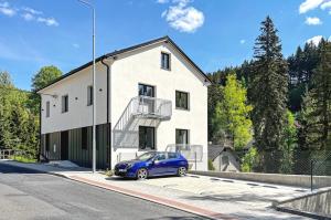 a blue car parked in front of a white building at Residence Pod Bublavou in Kraslice