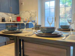 een keuken met borden en wijnglazen op een aanrecht bij Copper Pine - Refurbished - Contractors & families in Dowlais