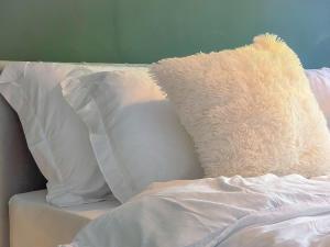 een knuffeldier zit op een bed met kussens bij Copper Pine - Refurbished - Contractors & families in Dowlais