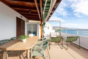 balcone con tavolo e sedie in legno di Miramar a Castell de Ferro