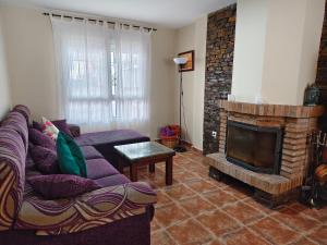 un soggiorno con divano e camino di Mirador del Duque a Güéjar-Sierra