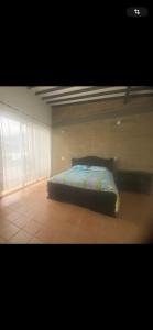 una camera da letto con un letto in una stanza con una finestra di CASA VACACIONAL CON PISCINAS EN SAN JERONIMO - CIUDADELA PREMIUm a Medellín Altre 30 foto