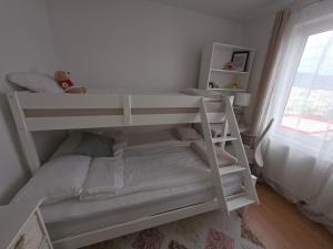 Ce lit superposé blanc se trouve dans une chambre blanche. dans l'établissement Apartament Abby, à Sighişoara
