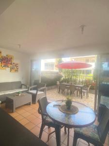 un patio con tavolo, sedie e ombrellone di CASA VACACIONAL CON PISCINAS EN SAN JERONIMO - CIUDADELA PREMIUm a Medellín