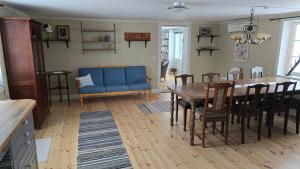 a dining room with a table and a blue couch at Kringelgården in Stamsmåla