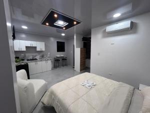 una stanza bianca con un letto e una cucina di Deramai a Santo Domingo de los Colorados