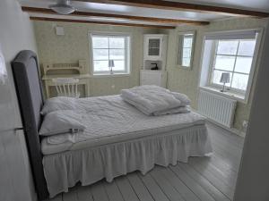 a bedroom with a bed and two windows at Kringelgården in Stamsmåla