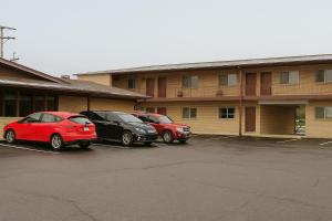zwei Autos auf einem Parkplatz vor einem Gebäude geparkt in der Unterkunft Canton Inn By OYO in Canton