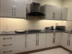 una cucina con mobili bianchi e una stufa di Executive 1-Bed Luxury Apartment with City View ! Zeta Mall Islamabad a Islamabad Altre 10 foto