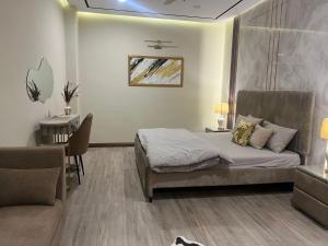 una camera da letto con un letto, una scrivania e un divano di Executive 1-Bed Luxury Apartment with City View ! Zeta Mall Islamabad a Islamabad