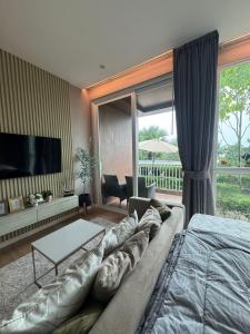 un salon avec un grand canapé et une télévision dans l'établissement Beachfront Luxury Studio Condo near Marriot Naiyang 50 1, à Phuket