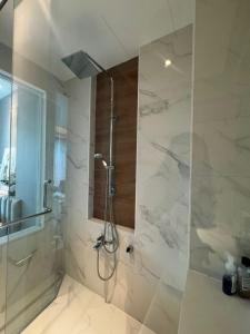 une salle de bain avec une douche avec une porte vitrée dans l'établissement Beachfront Luxury Studio Condo near Marriot Naiyang 50 1, à Phuket