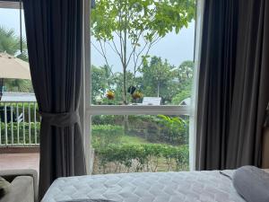 - une chambre avec une grande fenêtre donnant sur une cour dans l'établissement Beachfront Luxury Studio Condo near Marriot Naiyang 50 1, à Phuket