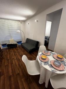 a living room with a table with plates on it at Beautiful Portal Santo Domingo Apartment in San Antonio