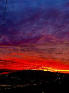 a sunset with a red and purple sky at Beautiful Portal Santo Domingo Apartment in San Antonio +1 photo