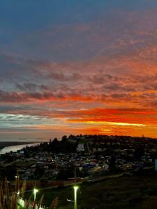 a view of a city with a sunset in the background at Beautiful Portal Santo Domingo Apartment in San Antonio