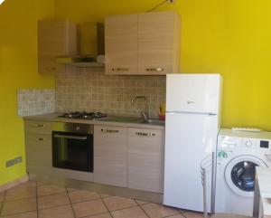 eine Küche mit einem weißen Kühlschrank und einer Waschmaschine in der Unterkunft Pension EA'S in Aichach