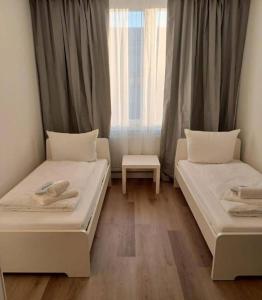 zwei Betten in einem Zimmer mit Fenster in der Unterkunft Pension EA'S in Aichach