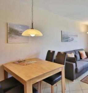 ein Wohnzimmer mit einem Holztisch und einer Couch in der Unterkunft Pension EA'S in Aichach