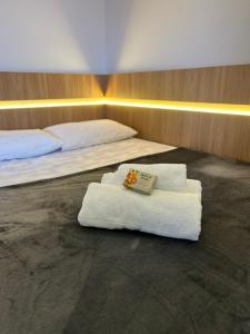 two beds with towels and a book on them at Haven Residence in Uberlândia