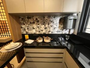 a kitchen with a counter with two pots on a stove at Haven Residence in Uberlândia +16 photos
