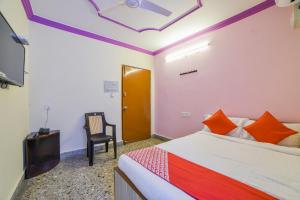 a bedroom with a bed and a chair in it at Hotel O Radika Residency in Warangal +36 photos